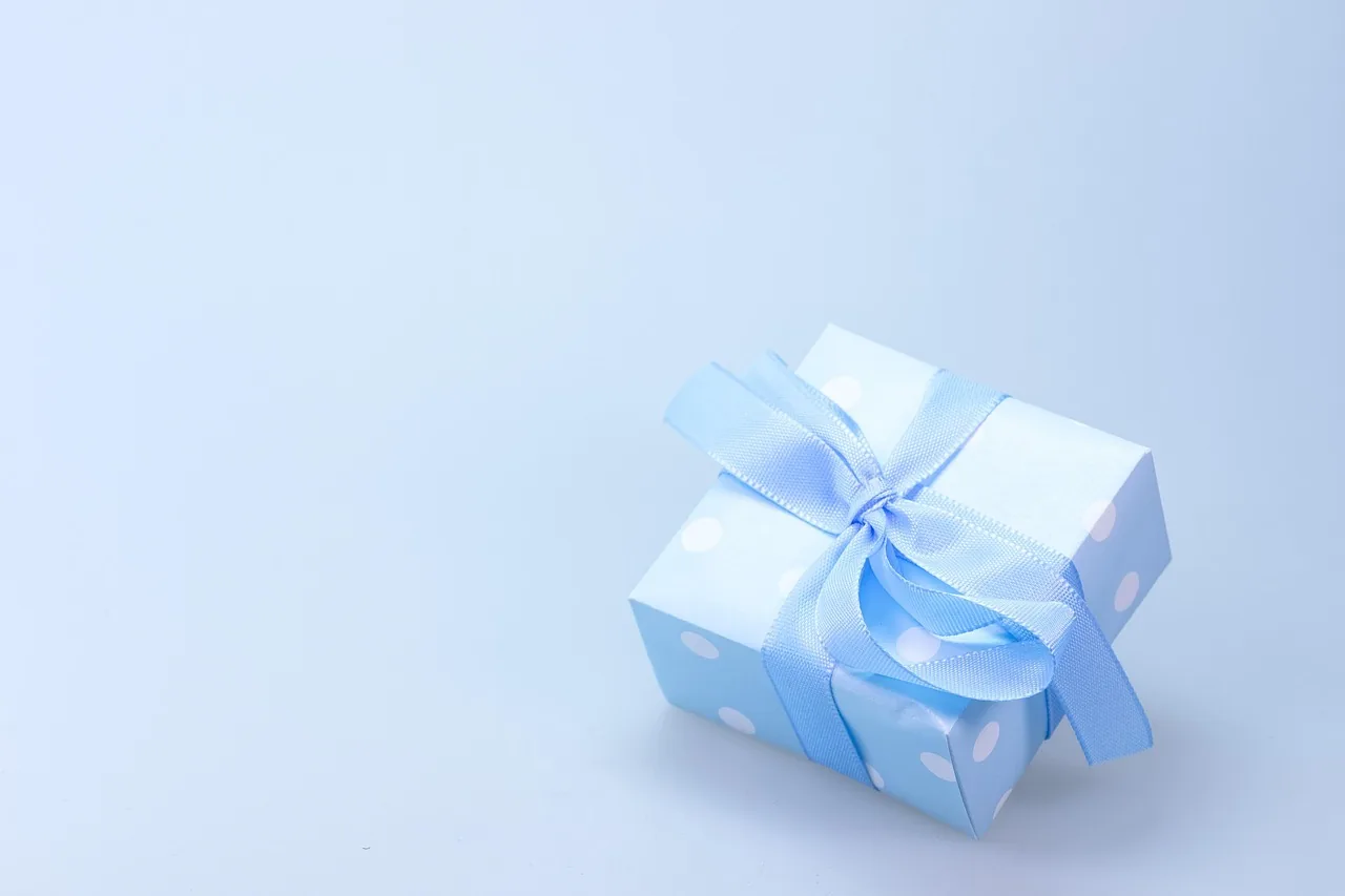 Gift box with a ribbon on a wooden table