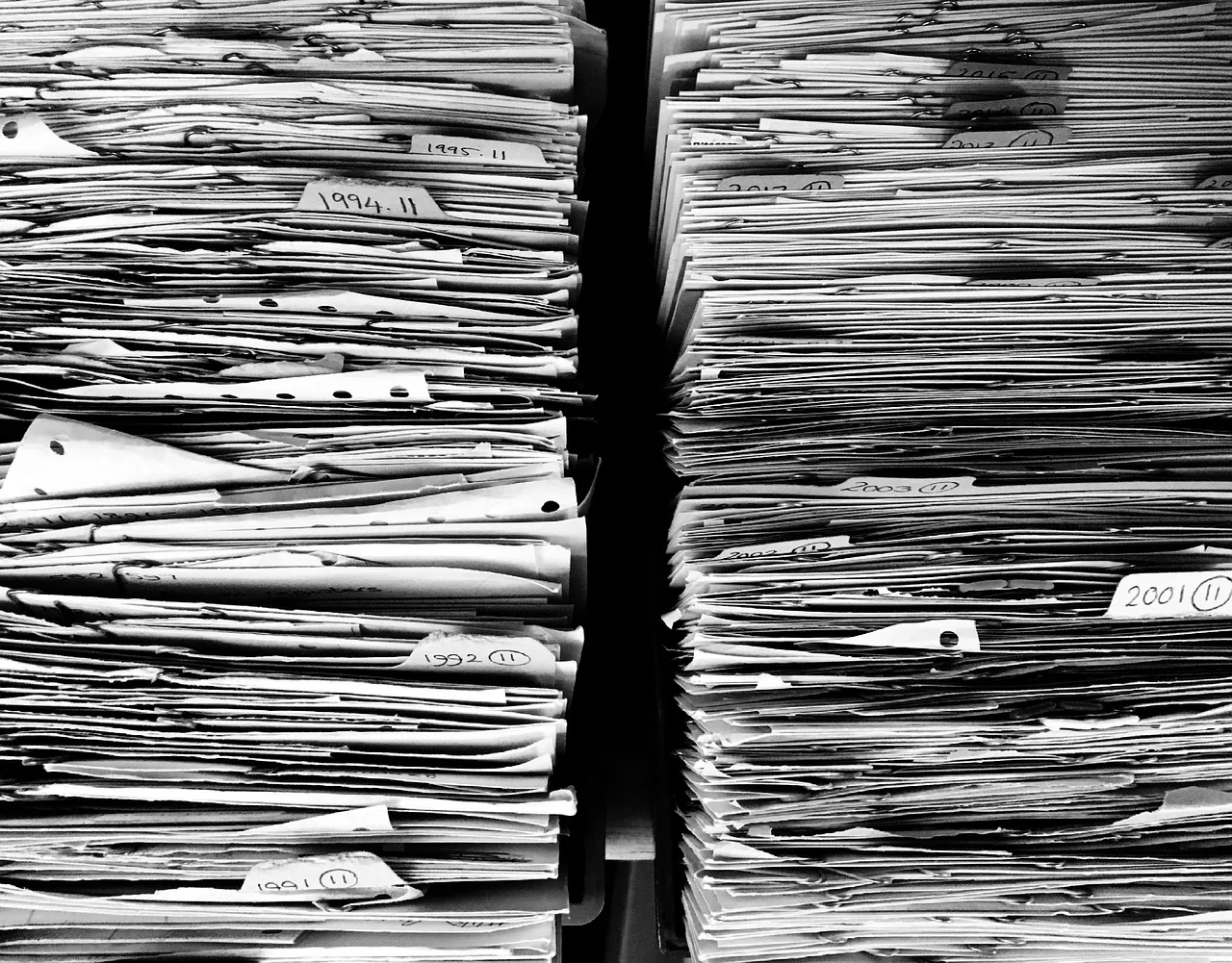 Classeurs et dossiers de suivi posés sur un bureau, fiches patients du cabinet