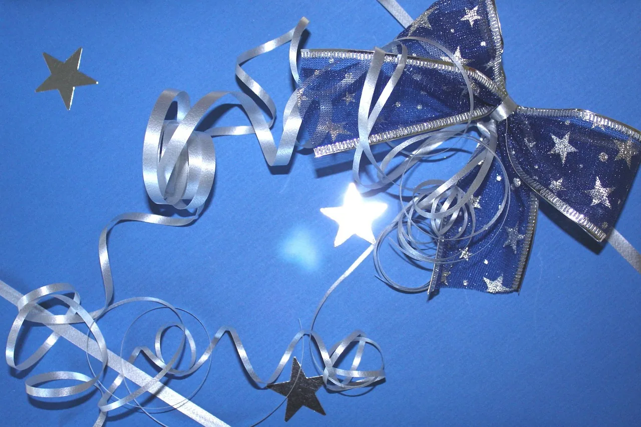 Blue gift bow and silver ribbon on a blue background